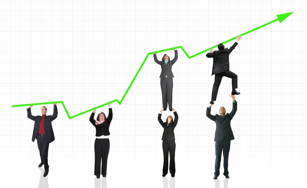 business people pushing a business graph upwards